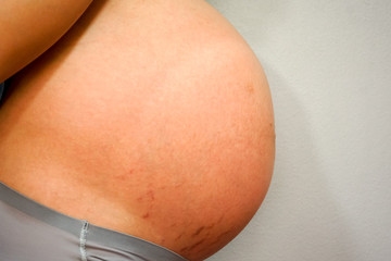 Image of pregnant woman touching her belly with hands