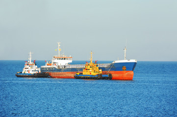 Fototapeta premium Tugboat assisting bulk cargo ship