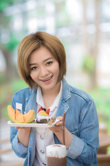 Happy beautiful girl  in coffee shop and drinking ice coffee and fruit.