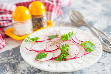 garden radish salad in a plate on a table, selective focus