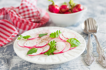 garden radish salad in a plate on a table, selective focus