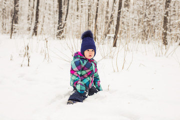 Fototapeta na wymiar Happy little kid is playing in snow, good winter weather