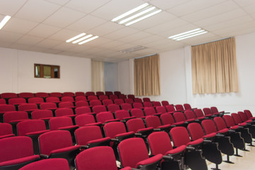 Auditorio con columnas de sillas rojas
