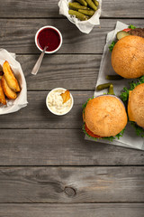 Burgers and cheeseburger with sauces, fries and pickles