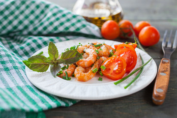 the cleared shrimps with tomatoes in a plate on a table, selective focus