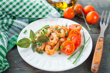 the cleared shrimps with tomatoes in a plate on a table, selective focus