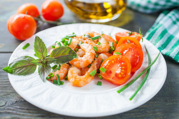 the cleared shrimps with tomatoes in a plate on a table, selective focus