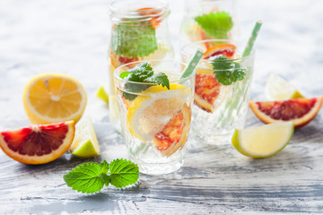 fresh citrus lemonade with mint in a glass on a concrete background, selective focus