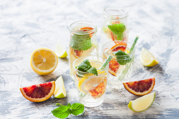 fresh citrus lemonade with mint in a glass on a concrete background, selective focus