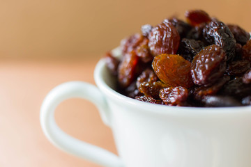 Dry black raisin in te white cup 
