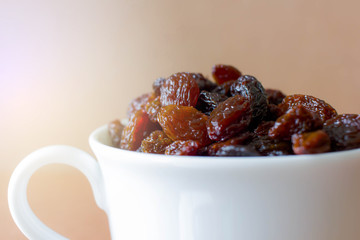 Dry black raisin in the white cup, food for heath