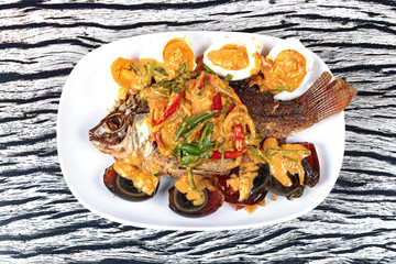 Curry-fried  tilapia fish with preserved egg and salted egg.