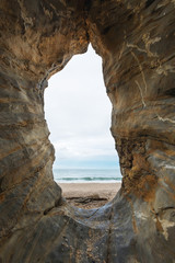 Vertical rock with hole at the beach