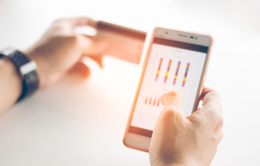 Blurred man using phone with credit card for business on white background,copy space.