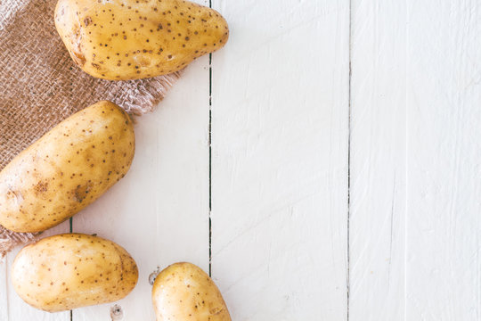 Fresh potatoes  on wooden background
