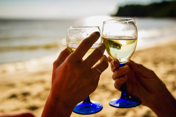 Young couple drinking wine on the beach.