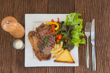 steak beef on white plate on wood background.