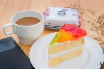Orange Cake on white plate and coffee on wood table.