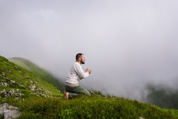 praying man on fog dark sky background