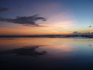 Fototapeta na wymiar Beautiful sunset on the tropical sandy beach in Bali. Indonesia