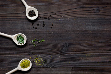 spices for cooking in spoon on wooden table top view