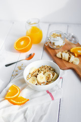 healthy breakfast bowl of yogurt with granola and banana