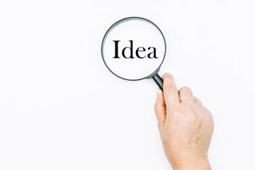 Hand holding magnifying glass with the word Idea