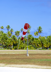 Cone wind measure wind direction in small airfield on the tropical island with palm trees at a...