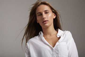 woman with hair flying in air wears man's shirt