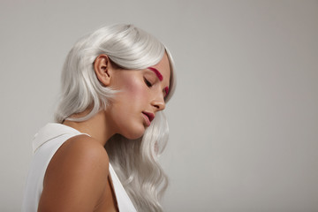 closeup of woman with grey white hair and pink makeup