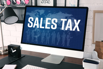 Modern workplace with computer. Text SALES TAX on screen. Online tax report concept.