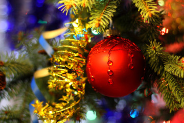 New Years and Christmas Eve celebration background with a  red ball decoration elegant arrangement  midnight, tree brunch. Copyspace. Gold light garland backdrops.