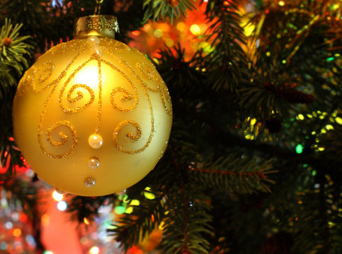 New Years and Christmas Eve celebration background with a  gold ball decoration elegant arrangement clock counting down to midnight, tree brunch. Copyspace. Bokeh light garland backdrops.