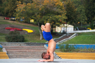 Athletic man doing yoga asanas in the park