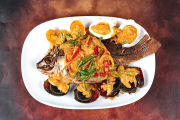 Curry-fried  tilapia fish with preserved egg and salted egg.