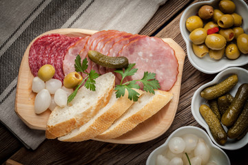 Tapas with sliced sausage, salami, olives, marinated onions, cuc