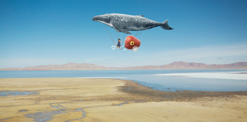 Fototapeta na wymiar Travel concept. Whale floats in the sky and carrying a happy sister with fantasy apple bike .