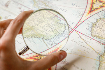 Fototapeta na wymiar Magnifying Glass in Woman’s Hand and Ancient Old Map