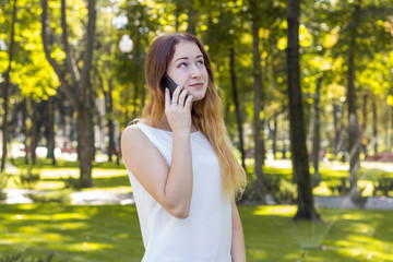 Fototapeta premium woman talking on the phone in the park