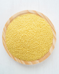 Raw couscous in wooden bowl