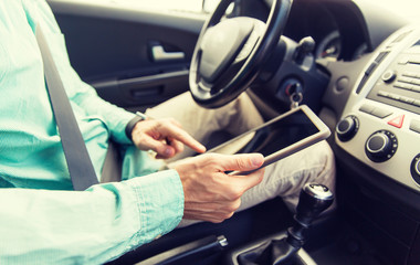 close up of young man with tablet pc driving car