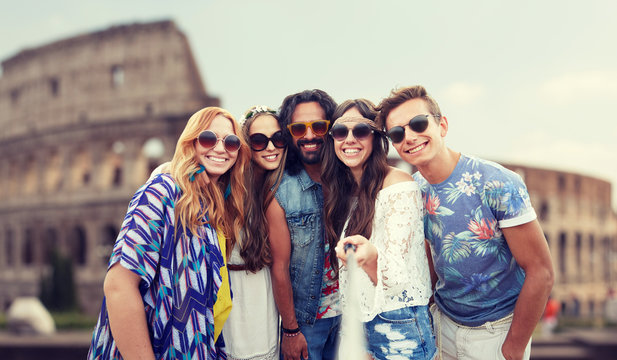 happy hippie friends with selfie stick at coliseum
