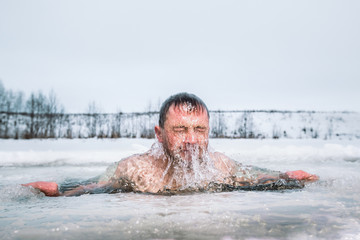 Man swimming in the ice hole