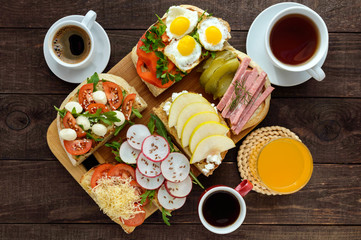 Many kinds of sandwiches, bruschetta, and tea, coffee, fresh juice - for a family breakfast. The top view
