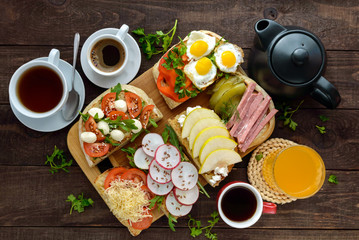 Many kinds of sandwiches, bruschetta, and tea, coffee, fresh juice - for a family breakfast. The top view