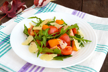 Dietary salad with pumpkin, fresh tomatoes, arugula and Parmesan.