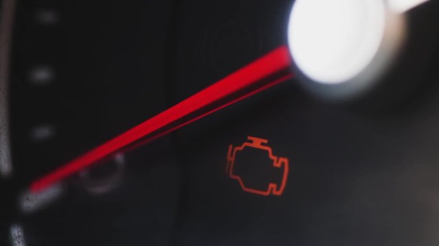 Close up footage of a check engine icon in a car.
