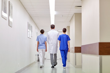 group of medics or doctors walking along hospital