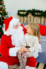 Santa Claus and cute girl getting ready for Christmas