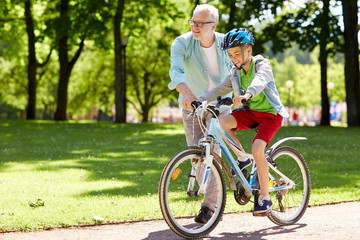 grandfather and boy with bicycle at summer park
